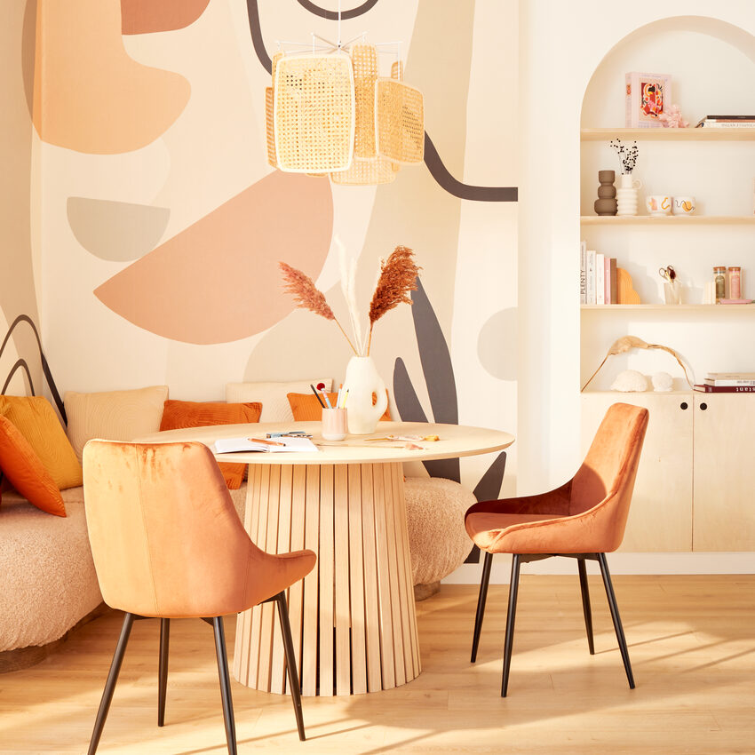 Coin repas avec étagère en niche, table ronde et motifs abstraits arrondis au mur