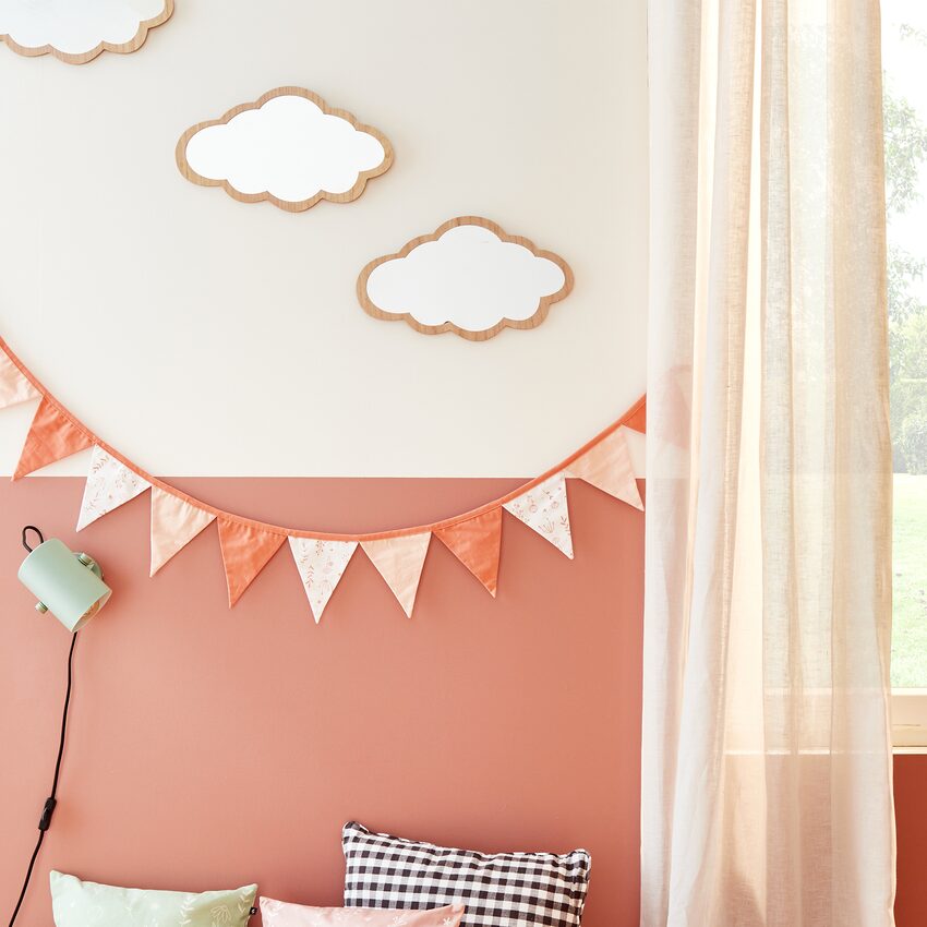 Miroirs en forme de nuage et guirlande rose sur mur blanc et rose