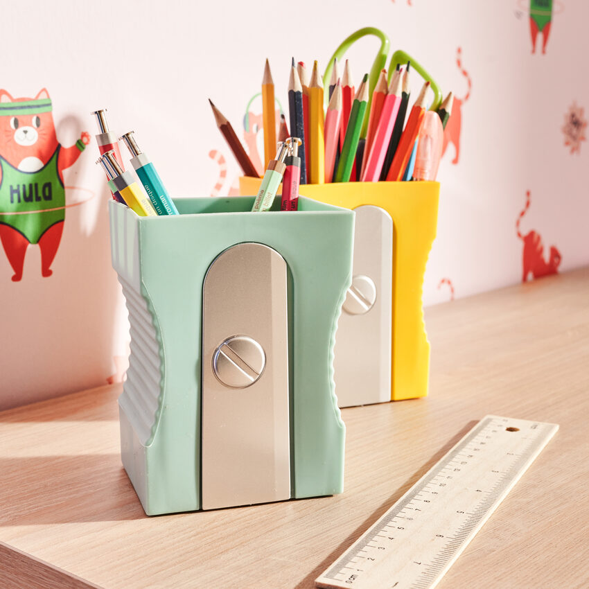 Pots à crayon en forme de taille-crayon avec crayons sur un bureau enfant