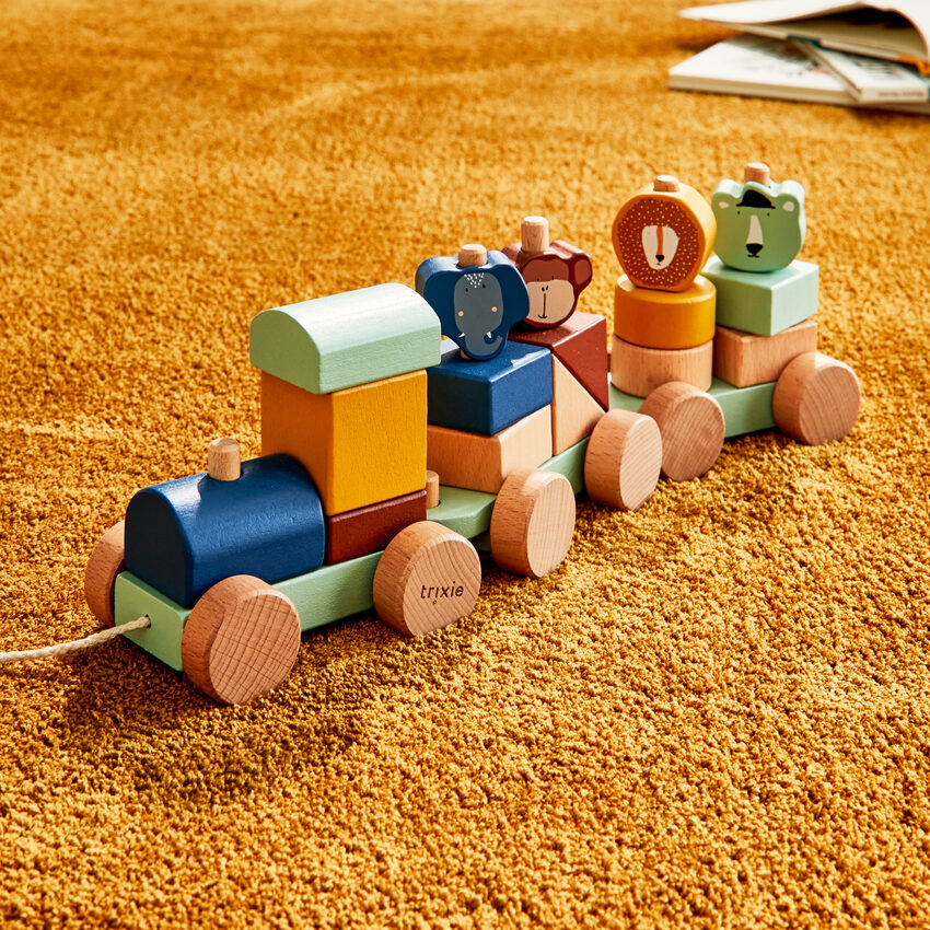 Train à blocs avec têtes d'animaux en bois de la marque Trixie sur tapis jaune