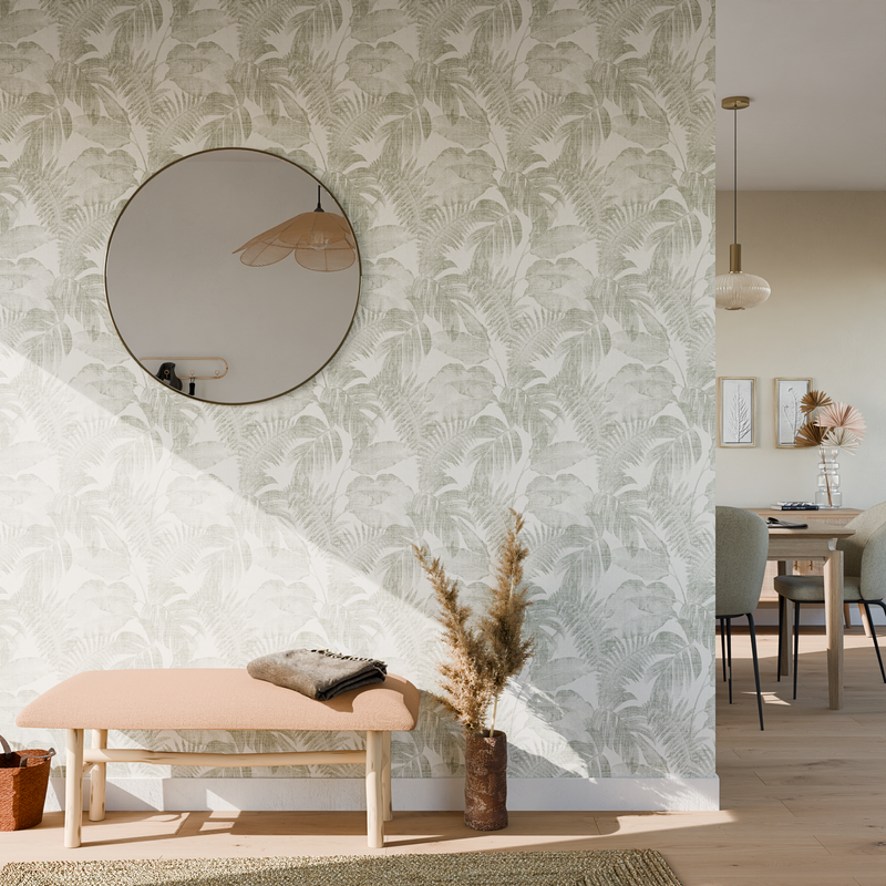 Papier peint à motifs feuillages verts, avec miroir rond et banc en bois clair dans une entrée