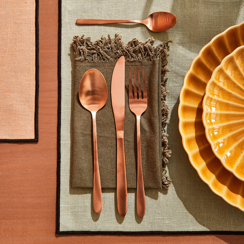 Couverts ROSEGOLD posés sur serviette et set de table verts