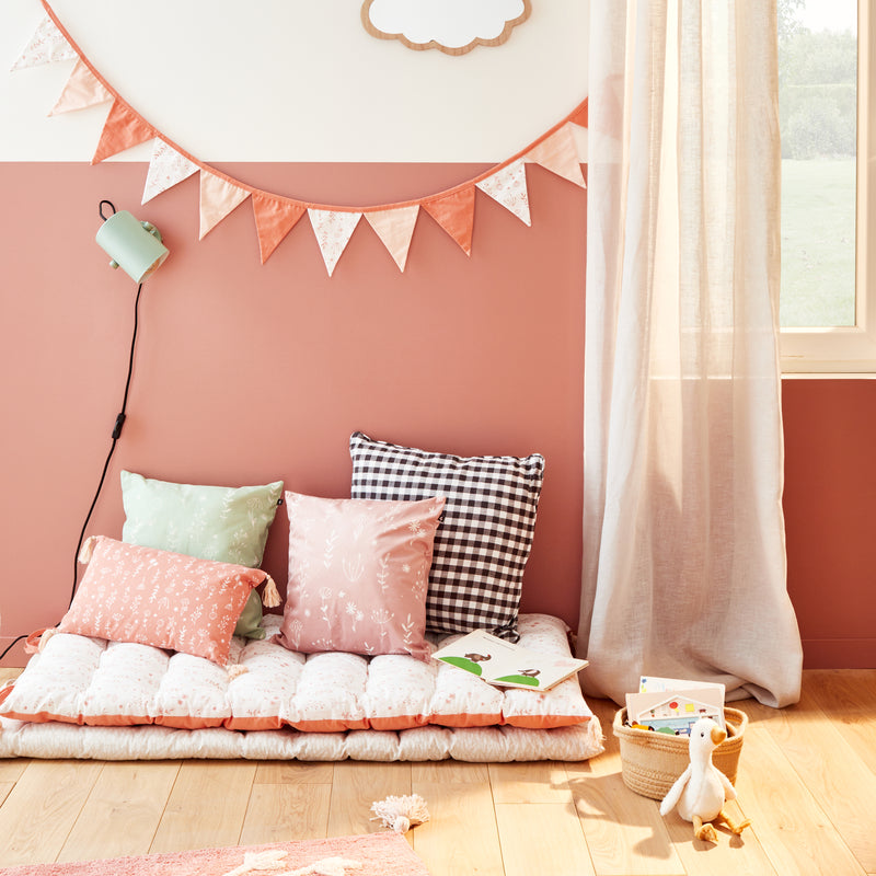 Coin lecture pour enfants avec coussins au sol et avec déco florale et aux tons chauds