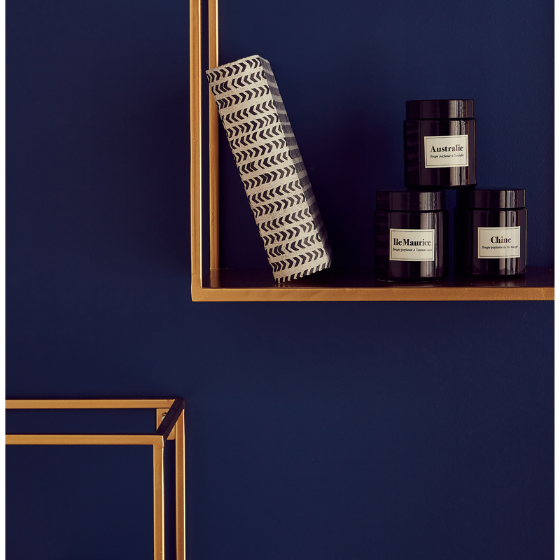 Mur bleu foncé, étagères dorées