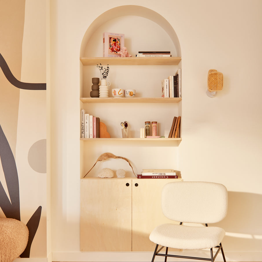 Étagère en niche et fauteuil dans des tons blancs