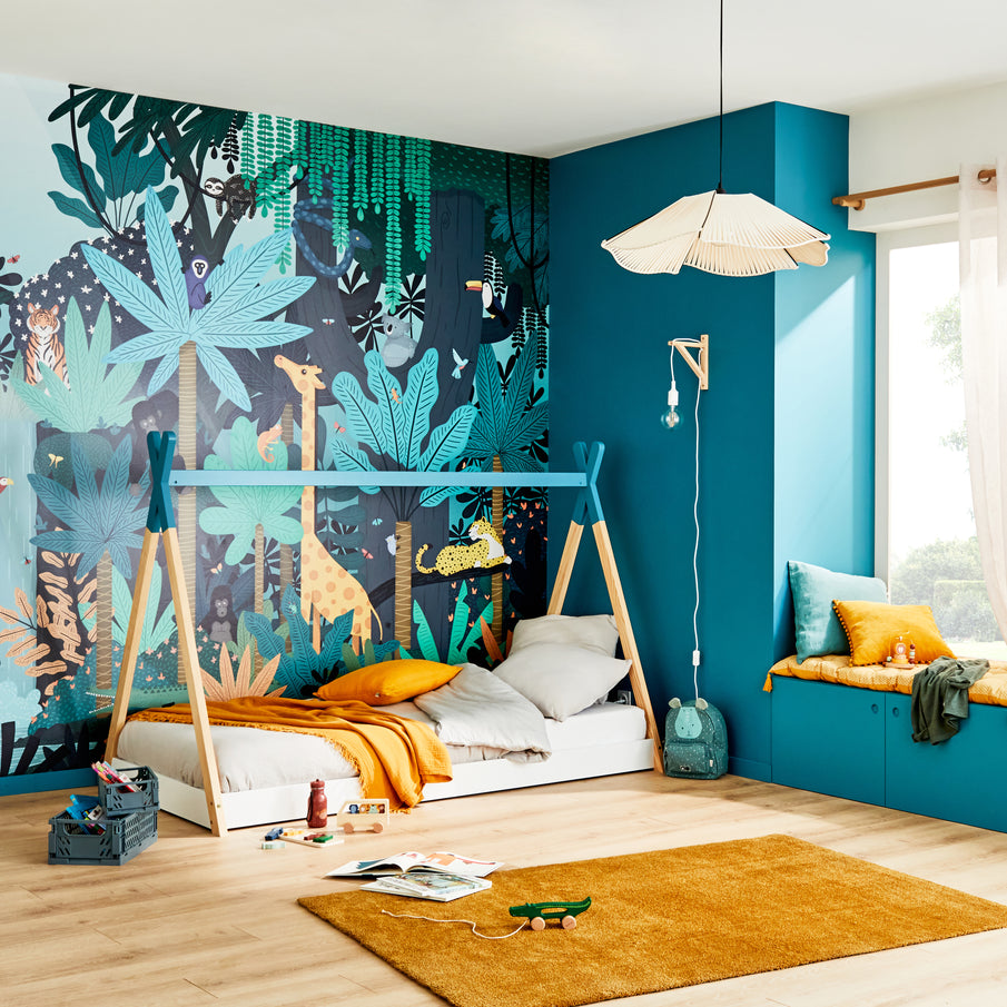 Chambre enfant dans les tons bleu paon avec un lit cabane et un papier peint jungle
