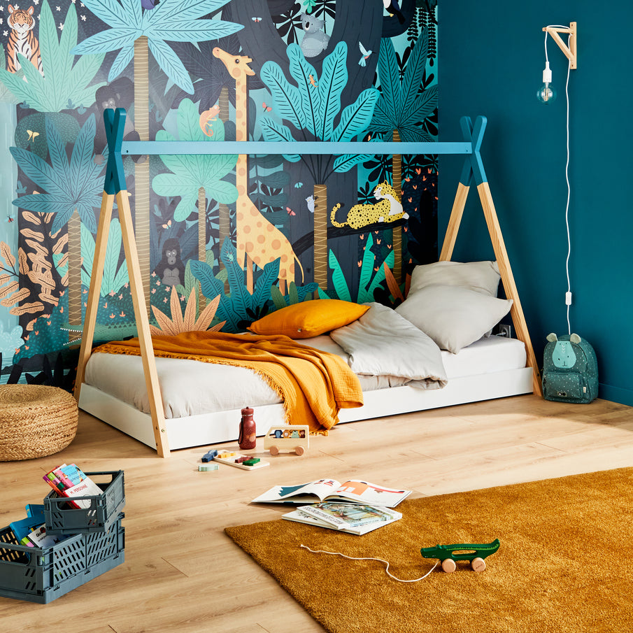 Chambre d'enfant avec un lit cabane devant un papier peint à motif jungle nocturne