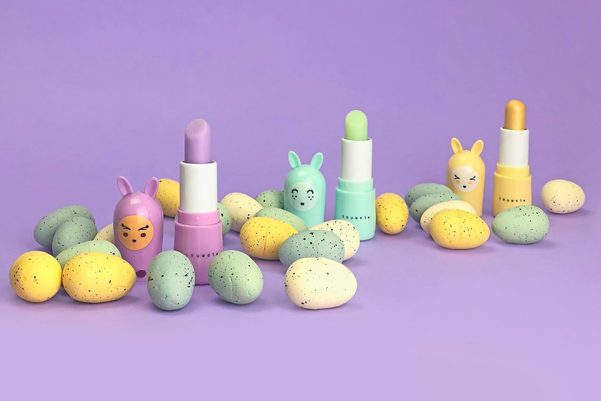 Baumes à lèvres lapin dévissés de la marque Inuwet dans un set design couleurs pastel