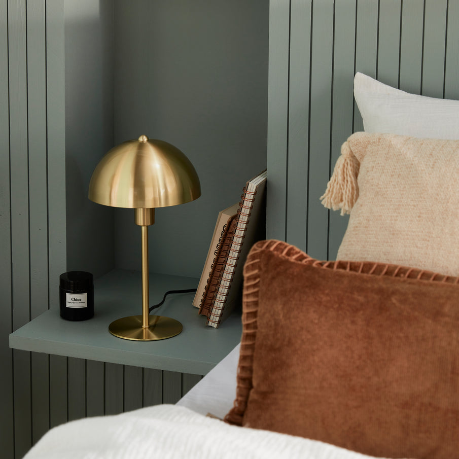 Lampe de chevet dorée dans chambre couleur vert-de-gris