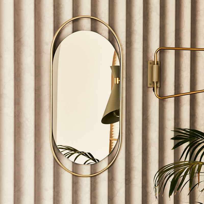 Miroir ovale doré dans une salle de bain, mur papier peint effet colonnes de marbre