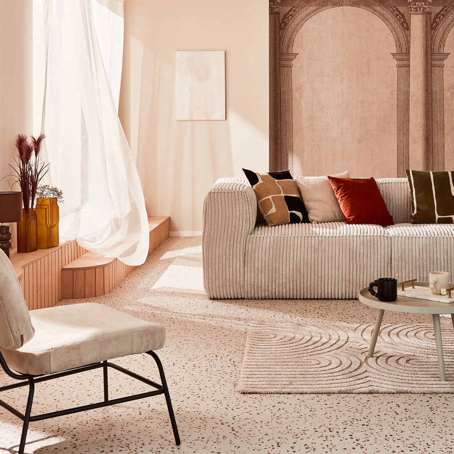 Salon clair avec canapé gris en velours côtelé et papier peint arches romaines