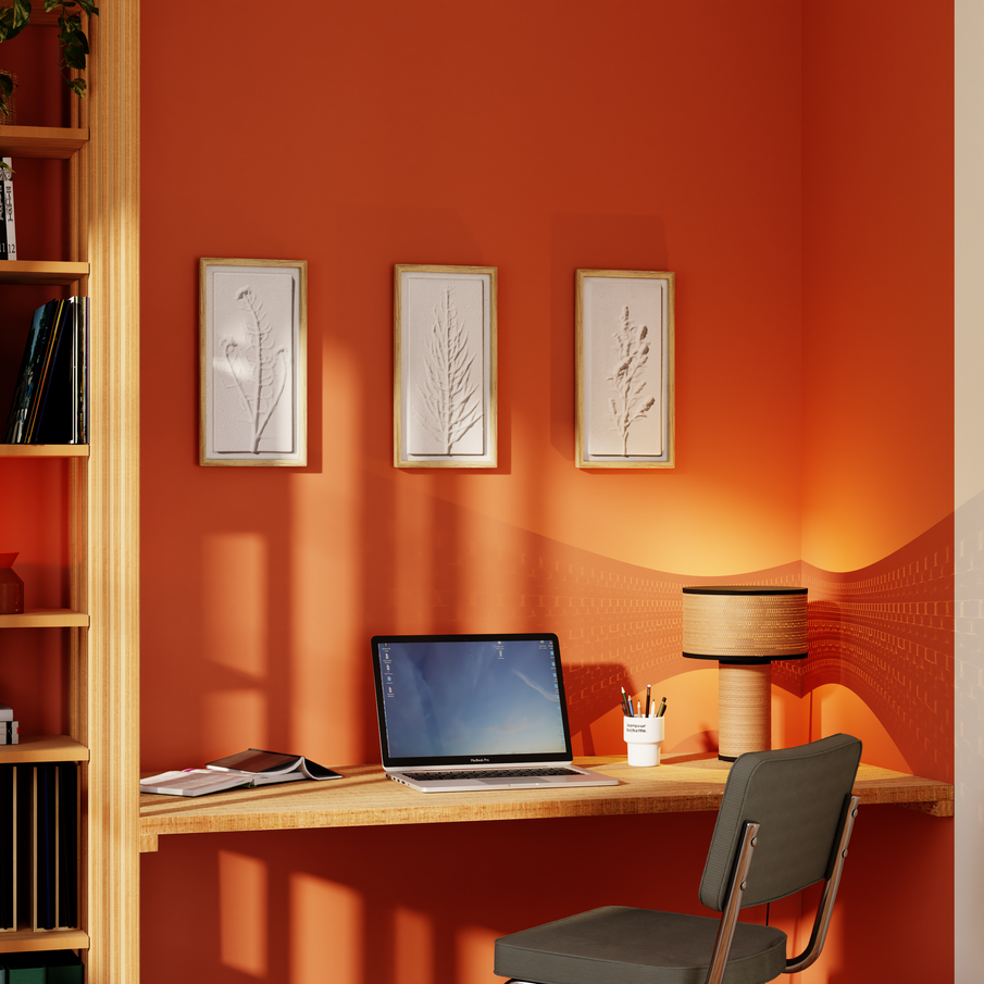 Coin bureau avec mur orange et trois cadres à motif végétal blanc