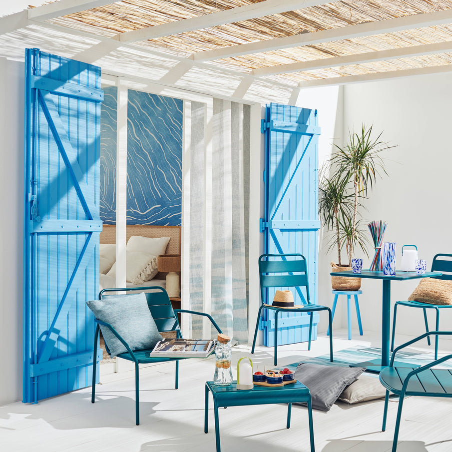 Terrasse dans les tons blancs et bleus, avec mobilier d'extérieur bleu indigo