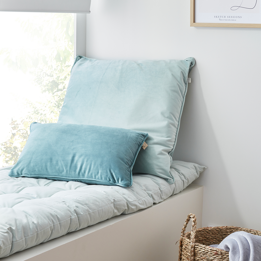 Banquette de coussins bleu ciel à la fenêtre