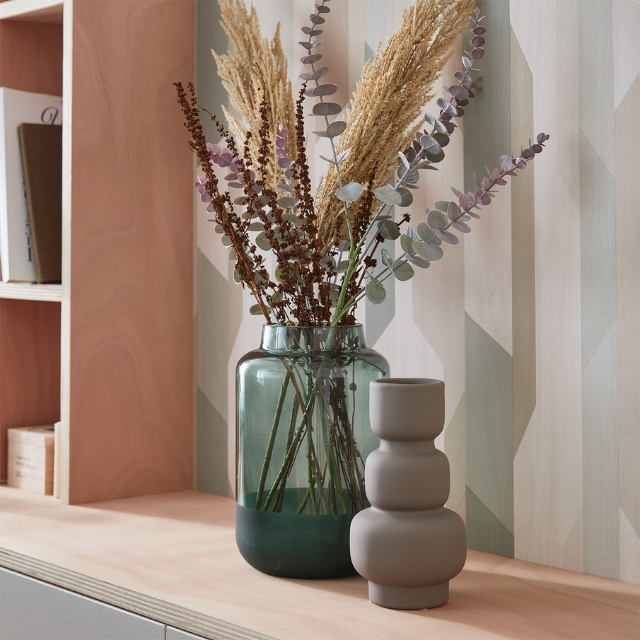 Vase transparent vert rempli de fleurs séchées