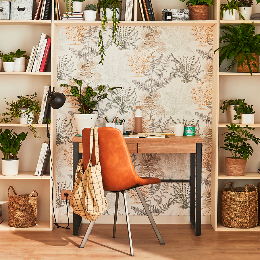 Bureau dans une niche de bibliothèque avec un papier peint blanc à motif de plantes