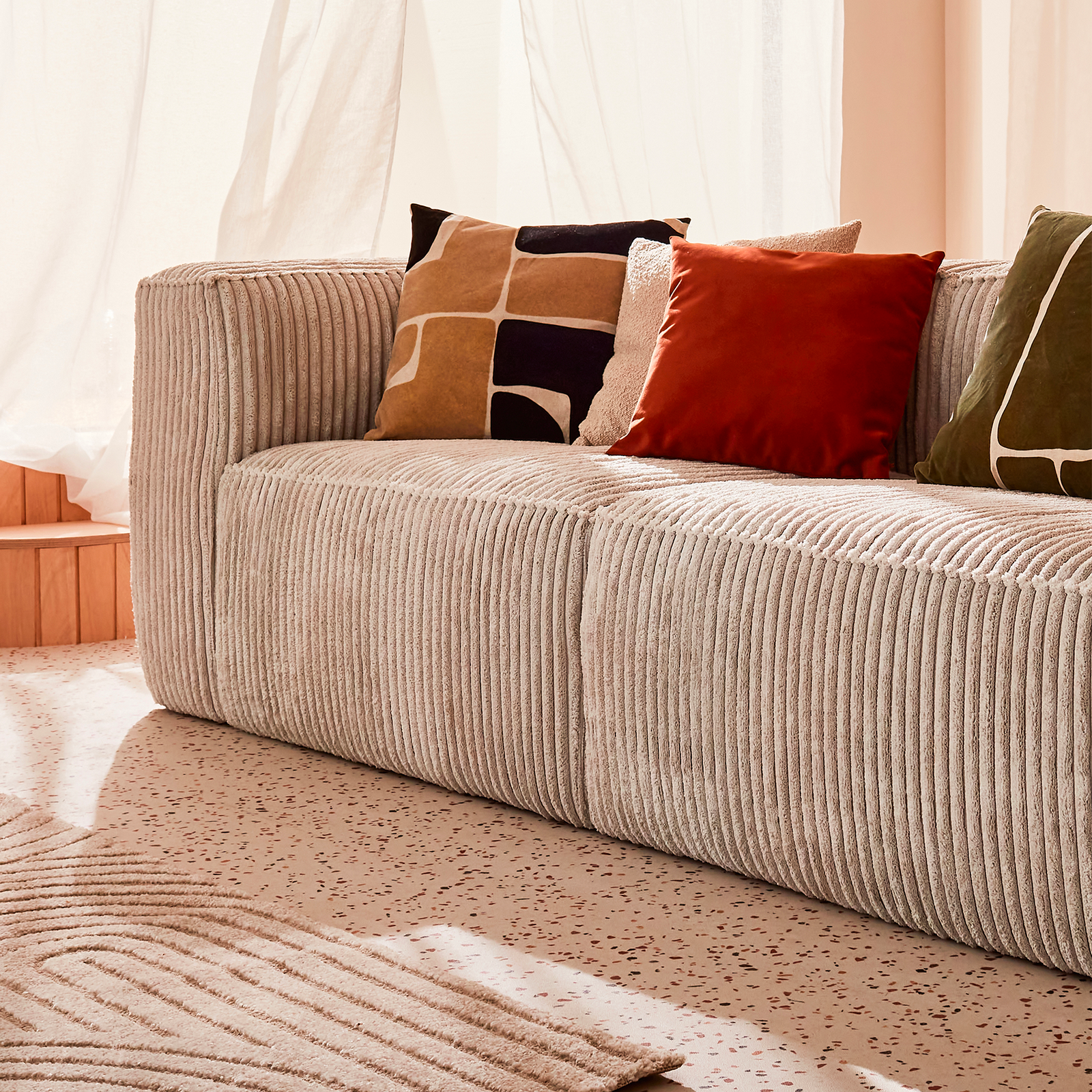 Canapé en velours côtelé beige et ses coussins