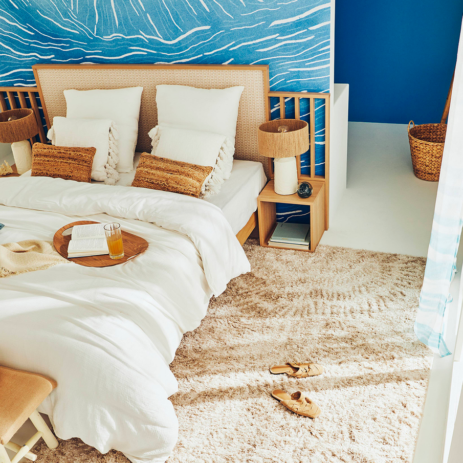 Tapis beige devant lit dans chambre style bord de mer