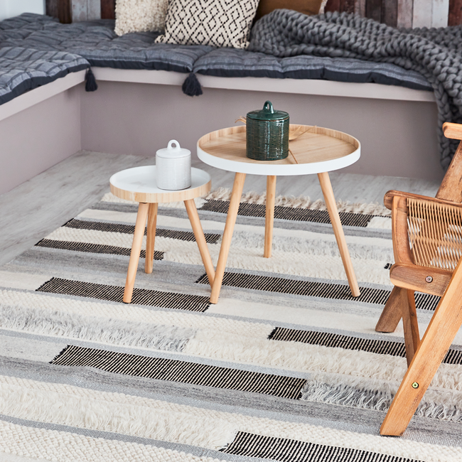 Tapis structuré en laine sous table basse blanche et vois dans un salon style scandinave