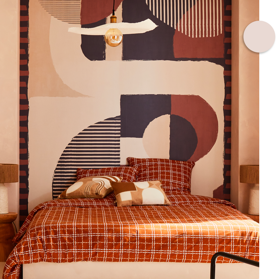 Papier peint aux courbes en beige, bleu et rouge dans chambre à coucher, linge de lit orange