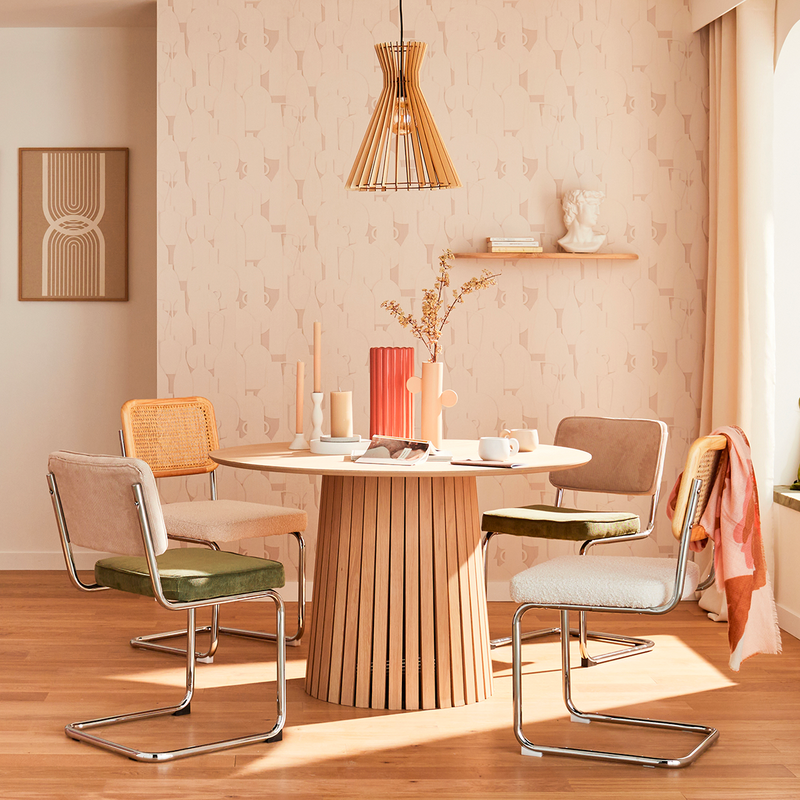 Salle à manger avec table ronde et chaises tubulaires dans les tons beiges
