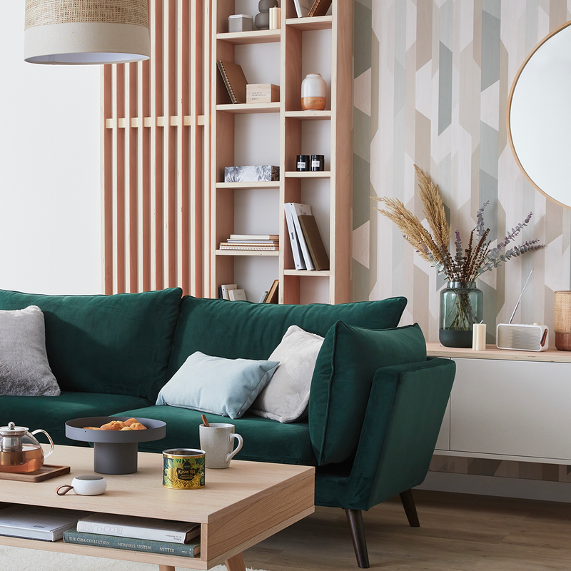Salon style scandinave avec papier peint géométrique, canapé vert et déco en bois
