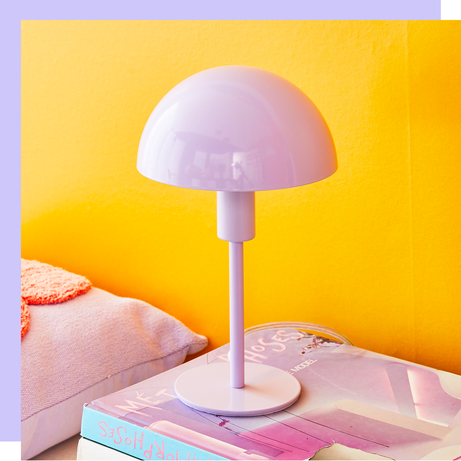 Lampe de chevet couleur lavande devant un mur jaune