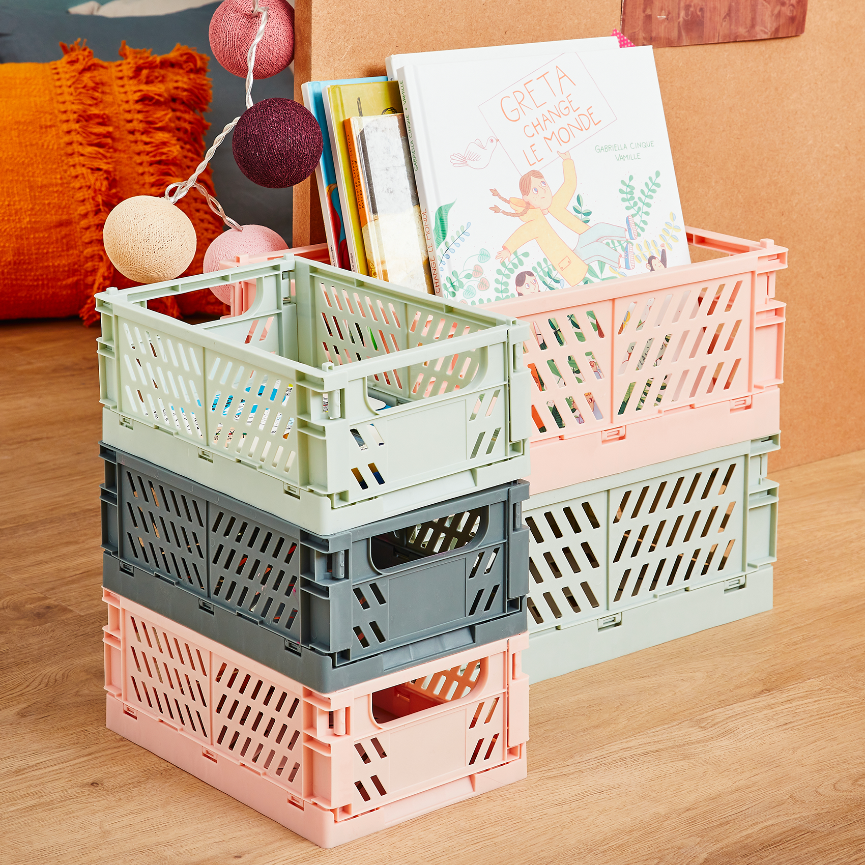 Caisses de rangements couleurs pastel empilées et contenant des albums enfants