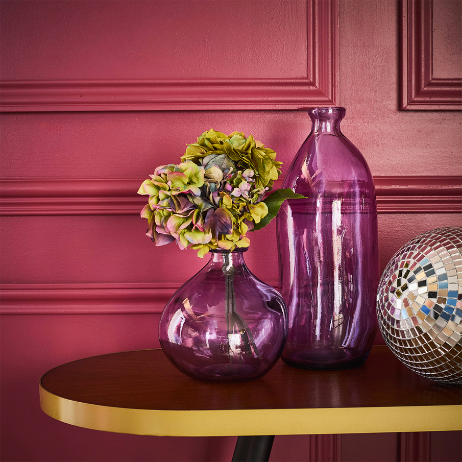 Vases en verre violet sur une console