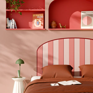 Papier peint rayé rose en tête de lit dans chambre rouge