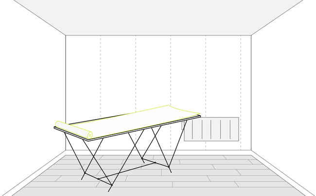 Rouleau de papier peint déroulé sur une table à tapisser dans une pièce