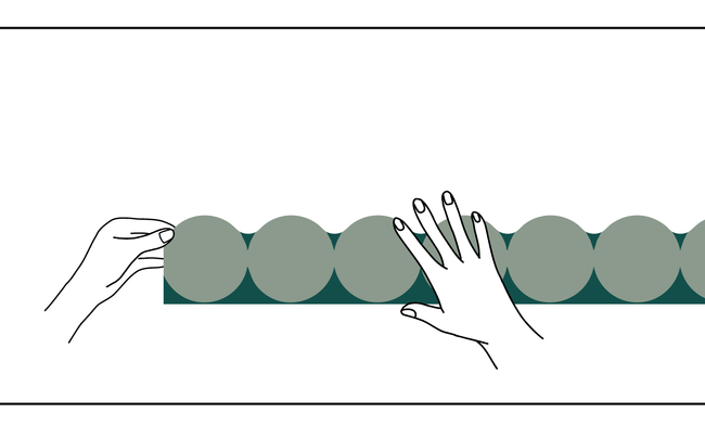 Dessin de mains repositionnant une frise verte au mur