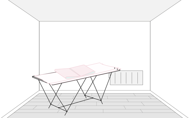 Lés de papier peint numérotés et pliés sur une table à tapisser dans une pièce
