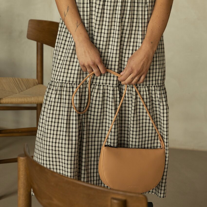 Femme tenant un sac à main bandoulière beige