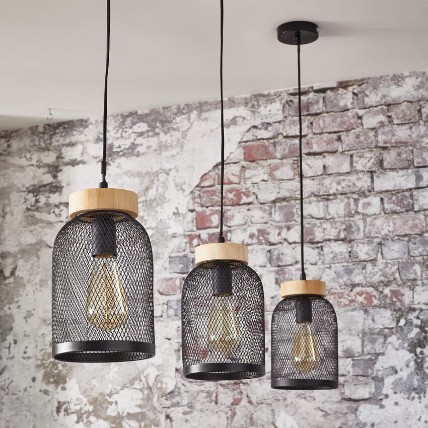 Trois suspensions métalliques noires devant mur effet pierre