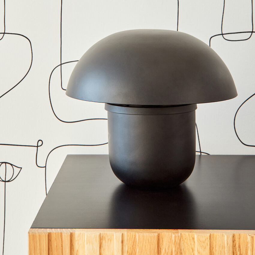 Lampe champignon noir posée sur un buffet noir