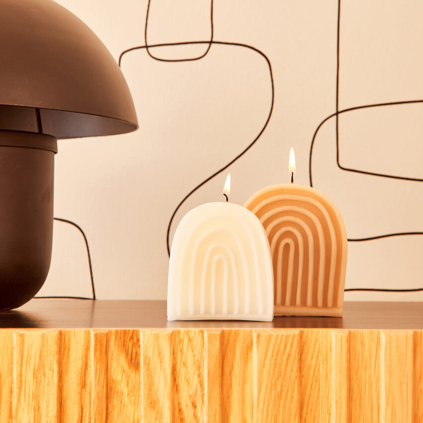 Bougies allumées en forme d'arche posées sur un buffet