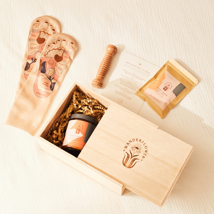 Boîte en bois semi-ouverte avec pot, entourée d'accessoires de réflexologie 