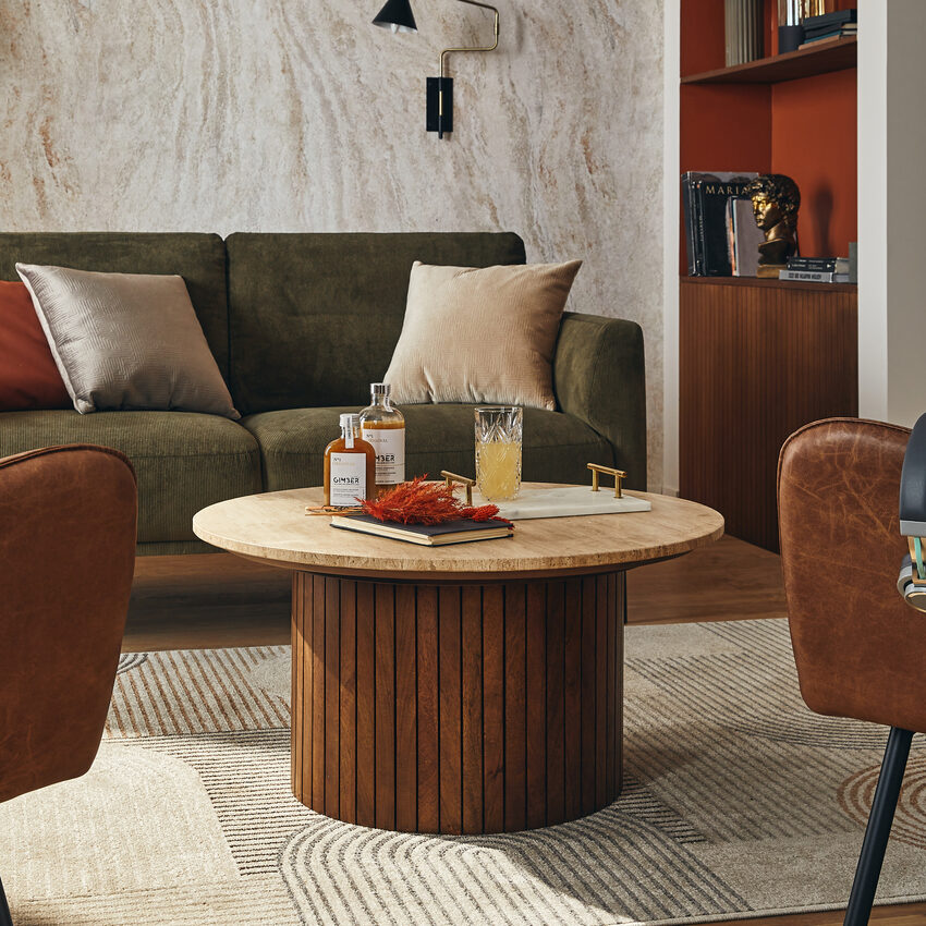 Table basse en bois et marbre dans un salon chic aux teintes cognac, vert et brun