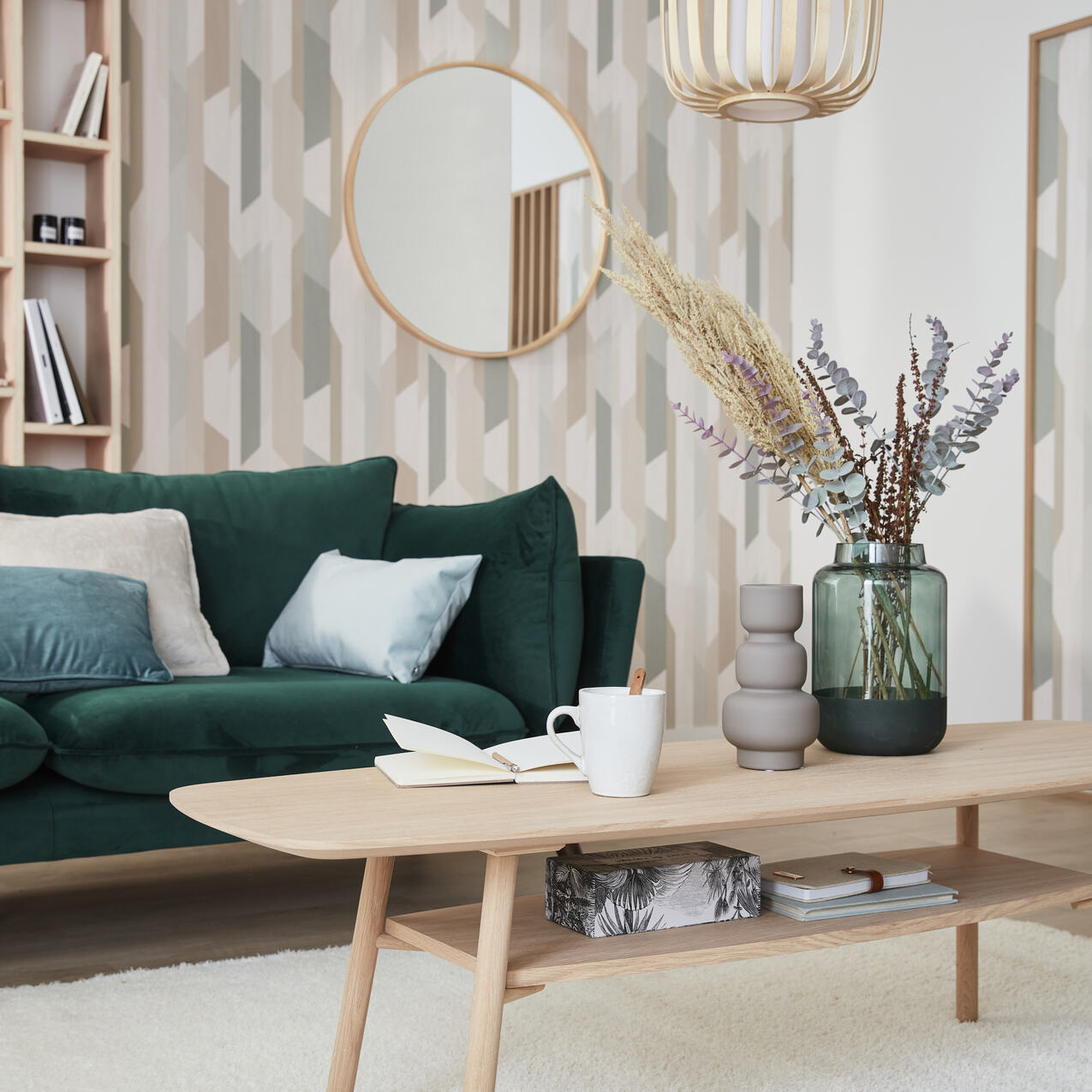 Salon scandinave avec canapé vert et papier peint à motif géométrique