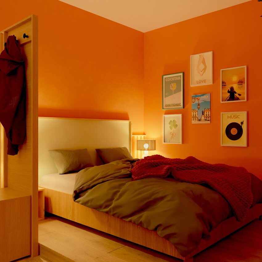 Coin lit avec mur de cadres et meuble WELCOME, ambiance tamisée