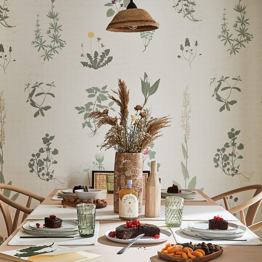 Table dressée style campagne chic devant un papier peint à motif herbier