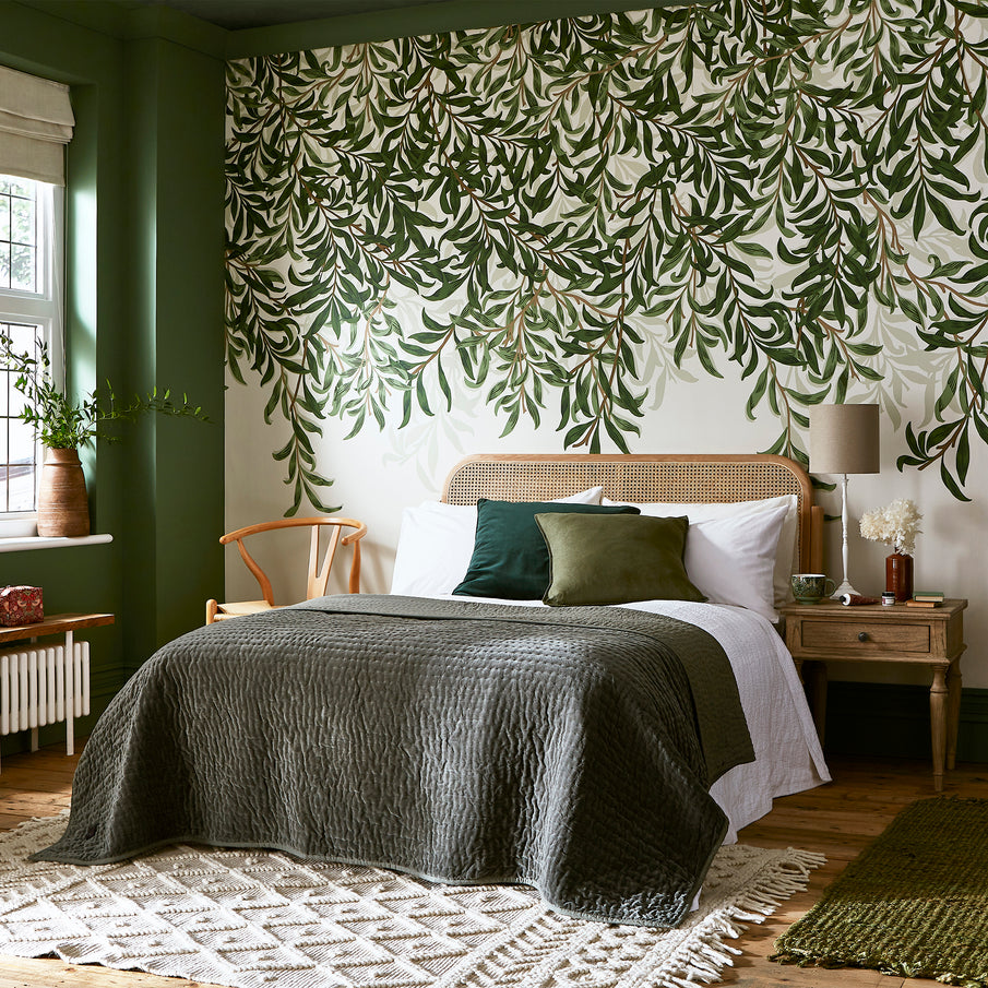 Chambre au ton vert, avec papier peint panoramique au motif de feuillage tombant en tête de lit