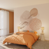 Chambre aux tons beige et orangé, papier peint panoramique beige au motif abstrait