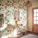 Entrée au papier peint à motif fleuri, console en bois et miroir rond au mur