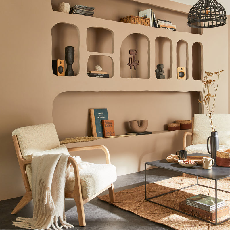 Salon aux murs couleur muscade avec alcôves creusées qui accueillent la déco