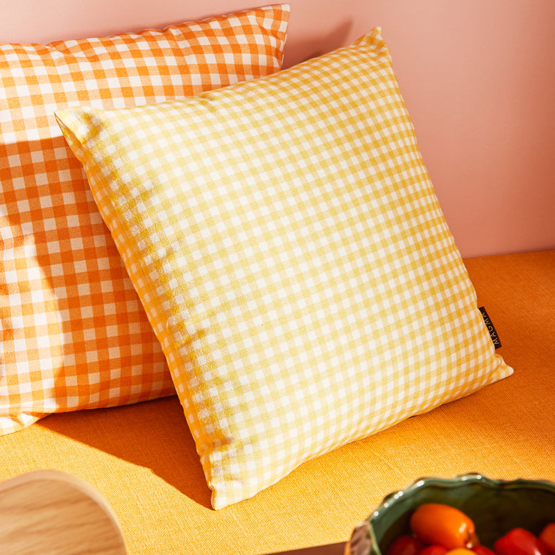 Coussins motif vichy jaune et orange sur banquette jaune