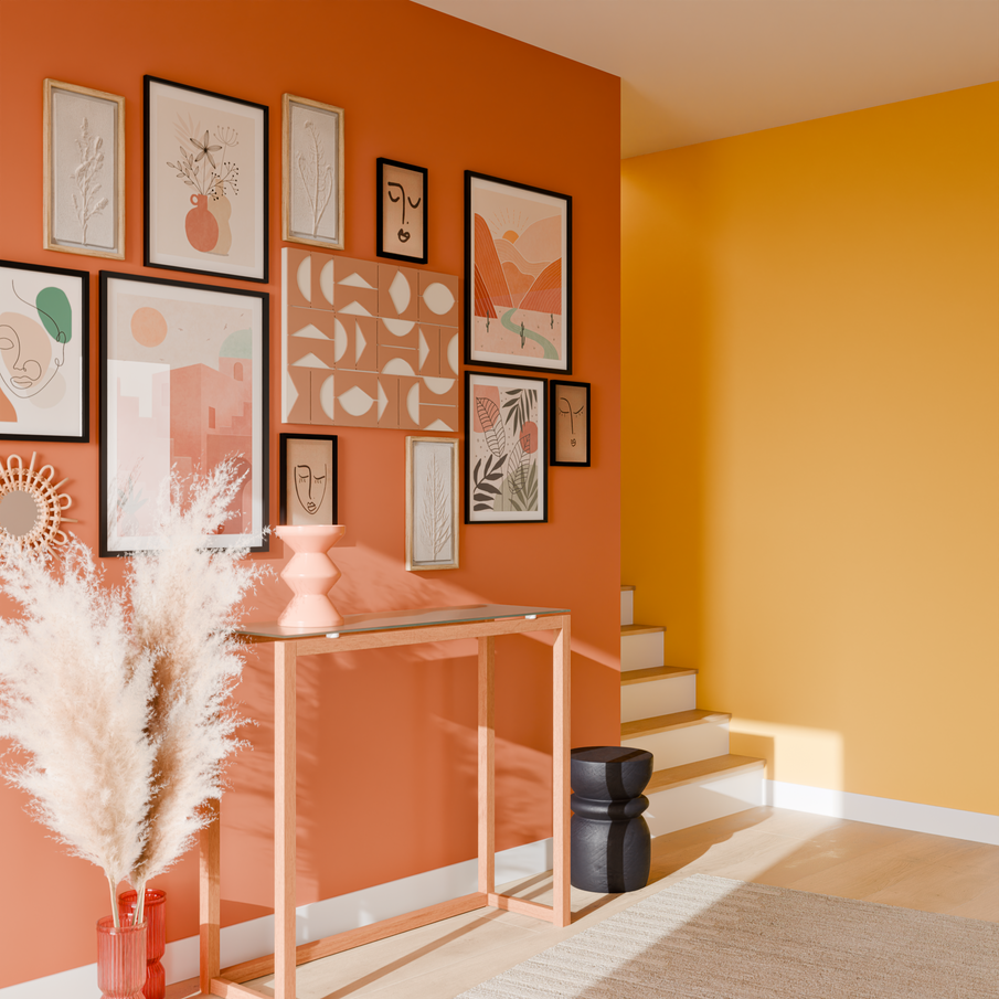 Entrée avec un mur jaune et un mur terracotta avec une accumulation de cadres