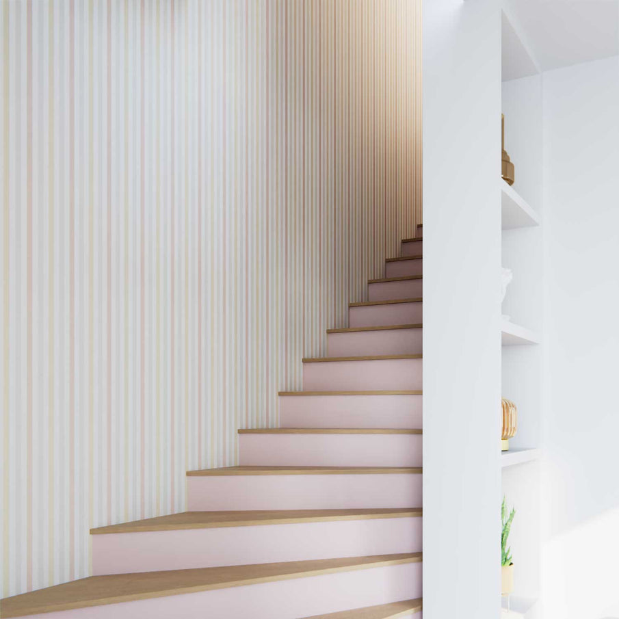 montée d'escalier peinte en rose clair et papier peint à rayures verticales multicolores au mur