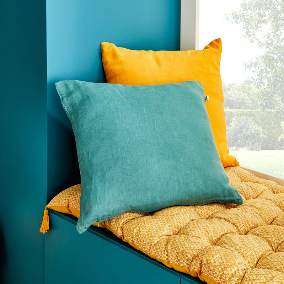Banquette bleu canard avec coussin bleu assorti et coussins jaunes